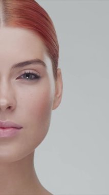 Stüdyo portresi, genç, güzel ve doğal kızıl saçlı kadın pozu. Yüz gerdirme, kozmetik ve makyaj konsepti. Dikey video.