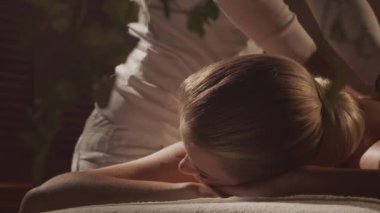 Kadın terapistten masaj tedavisi görüyor. Spa 'da masaj prosedürü. Sağlık, rahatlama, gençleşme ve sağIık kavramı.