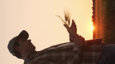 Farmer in front of a sunset agricultural landscape. Man in a countryside field. The concept of country life, food production, farming and country lifestyle.