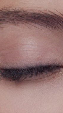 Cilt bakımı kremi süren genç, güzel ve doğal kızıl saçlı kadının stüdyo portresi. Yüz gerdirme, kozmetik ve makyaj konsepti. Dikey video.