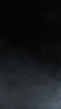 Siyah arka planda sigara içmek. Dikey video. Sis ya da buhar soyut koyu doku deseni. Siyah arkaplan.