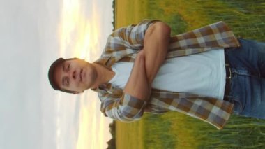 Farmer in front of a sunset agricultural landscape. Man in a countryside field. The concept of country life, food production, farming and country lifestyle.