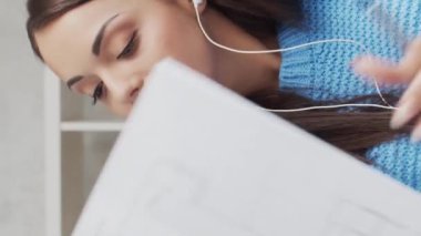 Genç ve çekici bir kadın evde dizüstü bilgisayar kullanarak çalışıyor. Serbest çalışan ya da öğrenci çevrimiçi konuşma yapıyor. Dikey video.