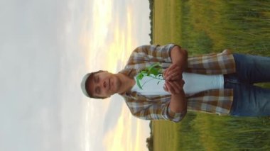 Farmer in front of a sunset agricultural landscape. Man in a countryside field. The concept of country life, food production, farming and country lifestyle.