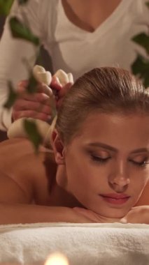 Kadın terapistten masaj tedavisi görüyor. Spa 'da masaj prosedürü. Sağlık, rahatlama, gençleşme ve sağIık kavramı.