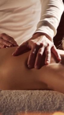 Kadın terapistten masaj tedavisi görüyor. Spa 'da masaj prosedürü. Sağlık, rahatlama, gençleşme ve sağIık kavramı.
