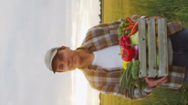 Günbatımı tarımının önündeki çiftçi. Kırsal kesimde bir adam. Kır hayatı, gıda üretimi, tarım ve kırsal yaşam tarzı kavramı.