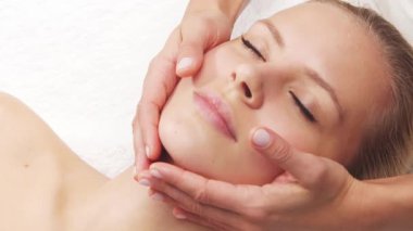 Kadın terapistten masaj tedavisi görüyor. Spa 'da masaj prosedürü. Sağlık, rahatlama, gençleşme ve sağIık kavramı.