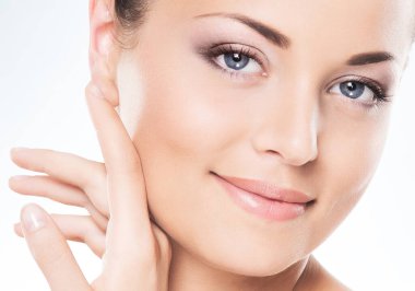 Beyaz arka planda genç, güzel ve sağlıklı bir kadının stüdyo portresi. Sağlık, kaplıca, makyaj ve yüz gerdirme konsepti.