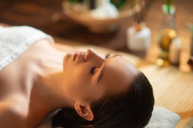 Genç, sağlıklı bir kadın egzotik geçmişiyle masaj yaptırıyor. Spa, sağlık ve dinlenme konsepti.