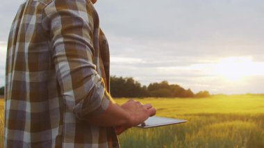 Farmer in front of a sunset agricultural landscape. Man in a countryside field. The concept of country life, food production, farming and country lifestyle.