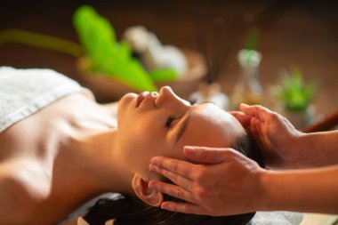 Genç, sağlıklı bir kadın egzotik geçmişiyle masaj yaptırıyor. Spa, sağlık ve dinlenme konsepti.