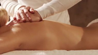 Kadın terapistten masaj tedavisi görüyor. Spa 'da masaj prosedürü. Sağlık, rahatlama, gençleşme ve sağIık kavramı.