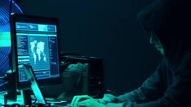 Aranan hackerlar virüs fidye yazılımını bodrumdaki bilgisayar ve dizüstü bilgisayarlarla kodluyorlar. Siber saldırı, sistem kırma ve kötü amaçlı yazılım kavramı.