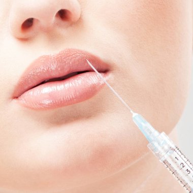 Güzel bir kadın yüzüne beyaz bir iğne vuruluyor.