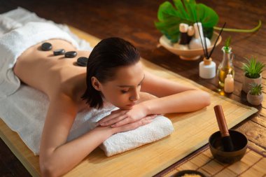 Genç, sağlıklı bir kadın egzotik geçmişiyle masaj yaptırıyor. Spa, sağlık ve dinlenme konsepti.