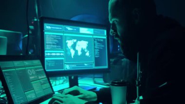 Aranan hackerlar virüs fidye yazılımını bodrumdaki bilgisayar ve dizüstü bilgisayarlarla kodluyorlar. Siber saldırı, sistem kırma ve kötü amaçlı yazılım kavramı.