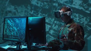 Bir askerin loş bir askeri kontrol odasındaki dramatik sahnesi, yoğun bir şekilde birden fazla bilgisayar ekranına odaklanmış, çok önemli operasyonel verileri gösteriyor..