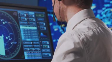 Kontrol kulesinde profesyonel hava trafik kontrolörü. Uçak kontrol subayı radar, bilgisayar navigasyon ve dijital haritalar kullanarak çalışır. Yakın plan portre. Havacılık kavramı.