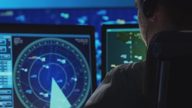 Kontrol kulesinde profesyonel hava trafik kontrolörü. Uçak kontrol subayı radar, bilgisayar navigasyon ve dijital haritalar kullanarak çalışır. Yakın plan portre. Havacılık kavramı.