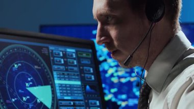 Kontrol kulesinde profesyonel hava trafik kontrolörü. Uçak kontrol subayı radar, bilgisayar navigasyon ve dijital haritalar kullanarak çalışır. Yakın plan portre. Havacılık kavramı.
