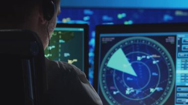 Kontrol kulesinde profesyonel hava trafik kontrolörü. Uçak kontrol subayı radar, bilgisayar navigasyon ve dijital haritalar kullanarak çalışır. Yakın plan portre. Havacılık kavramı.
