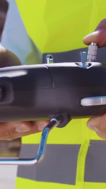 İnşaat alanının önünde duran profesyonel müteahhit. Kasklı ve yelekli ustabaşı. Ofis binası ve vinç arka planı. İş, gayrimenkul ve yatırım kavramları.