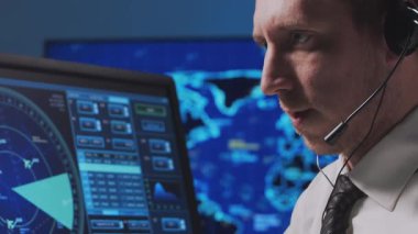 Kontrol kulesinde profesyonel hava trafik kontrolörü. Uçak kontrol subayı radar, bilgisayar navigasyon ve dijital haritalar kullanarak çalışır. Yakın plan portre. Havacılık kavramı.