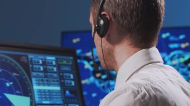 Kontrol kulesinde profesyonel hava trafik kontrolörü. Uçak kontrol subayı radar, bilgisayar navigasyon ve dijital haritalar kullanarak çalışır. Yakın plan portre. Havacılık kavramı.