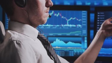 Tüccar, çalışma istasyonu ve analiz teknolojisi kullanarak ofiste çalışıyor. Profesyonel şifreleme simsarının işyeri. Yakın plan portre. Küresel finans piyasaları, iş stratejisi, döviz kurları ve bankacılık kavramları.