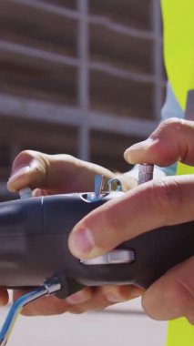 İnşaat alanının önünde duran profesyonel müteahhit. Kasklı ve yelekli ustabaşı. Ofis binası ve vinç arka planı. İş, gayrimenkul ve yatırım kavramları.