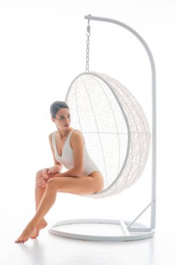 Beyaz mayo giyen genç, fit ve güzel esmer kadın beyaz arka planda izole edilmiş. Sağlık, diyet, spor ve spor kavramı.