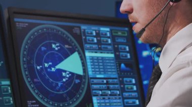 Kontrol kulesinde profesyonel hava trafik kontrolörü. Uçak kontrol subayı radar, bilgisayar navigasyon ve dijital haritalar kullanarak çalışır. Yakın plan portre. Havacılık kavramı.