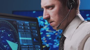 Kontrol kulesinde profesyonel hava trafik kontrolörü. Uçak kontrol subayı radar, bilgisayar navigasyon ve dijital haritalar kullanarak çalışır. Yakın plan portre. Havacılık kavramı.