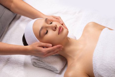 Sağlıklı genç bir kadın beyaz arka planda masaj yaptırıyor. Spa, sağlık ve dinlenme konsepti.