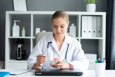 Tıp bürosunda çalışan genç ve profesyonel bir kadın doktor. Sağlık ve tıp konsepti. Doğal görünüş.