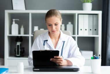 Tıp bürosunda çalışan genç ve profesyonel bir kadın doktor. Sağlık ve tıp konsepti. Doğal görünüş.