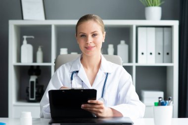 Tıp bürosunda çalışan genç ve profesyonel bir kadın doktor. Sağlık ve tıp konsepti. Doğal görünüş.