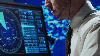 Kontrol kulesinde profesyonel hava trafik kontrolörü. Uçak kontrol subayı radar, bilgisayar navigasyon ve dijital haritalar kullanarak çalışır. Yakın plan portre. Havacılık kavramı.
