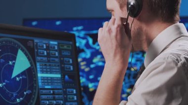 Kontrol kulesinde profesyonel hava trafik kontrolörü. Uçak kontrol subayı radar, bilgisayar navigasyon ve dijital haritalar kullanarak çalışır. Yakın plan portre. Havacılık kavramı.