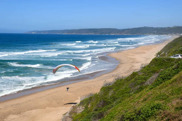 Person flying his paraglider on the beach of Wilderness in South Africa