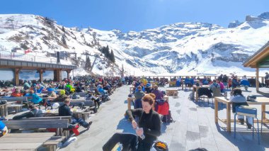 Engelberg, İsviçre - 9 Nisan 2023: İsviçre Alplerinde Engelberg üzerinde bir kayak restoranında yemek yiyen insanlar