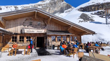 Engelberg, İsviçre - 9 Nisan 2023: İsviçre Alplerinde Engelberg üzerinde bir kayak restoranında yemek yiyen insanlar