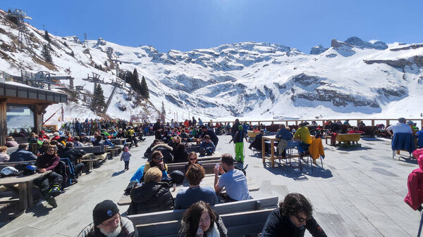Engelberg, Switzerland - 9 April 2023: people eating on a ski restaurant over Engelberg on the Swiss alps