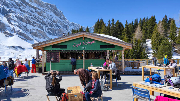 Engelberg, Switzerland - 9 April 2023: people eating on a ski restaurant over Engelberg on the Swiss alps