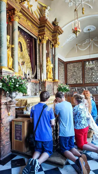 stock image Vilnius, Lithuania - 1 June 2024: people praying at the black madonna on gate of dawn chapel at Vilnius in Lithuania