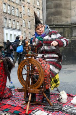 Edinburgh, Scotland - 30 March 2024: traditional wool spinner woman at Edinburgh in Scotland clipart