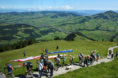 Ebenalp, Switzerland - 14 July 2024: people practicing parapenting at Ebenalp on the Swiss alps clipart