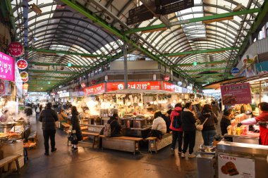 Seul, Güney Kore - 16 Ocak 2025: Güney Kore 'deki bir Seul pazarında yemek yiyen insanlar