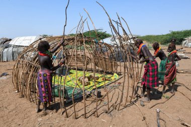 Omorate, Etiyopya - 13 Ağustos 2025: Etiyopya 'da Omorate' de bir kulübe inşa eden kadın